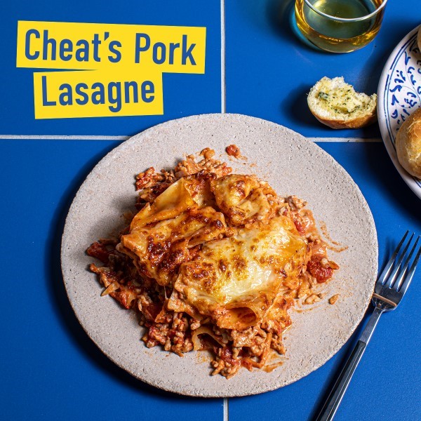 Pork lasagne on a white plate with recipe title graphic